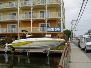 Yellow and white boat sits in front of hotel on an IMM Quality Superlift boat lift