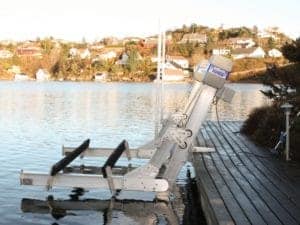 IMM Quality elevator boat lift sits empty on canal with dock installation on a lake